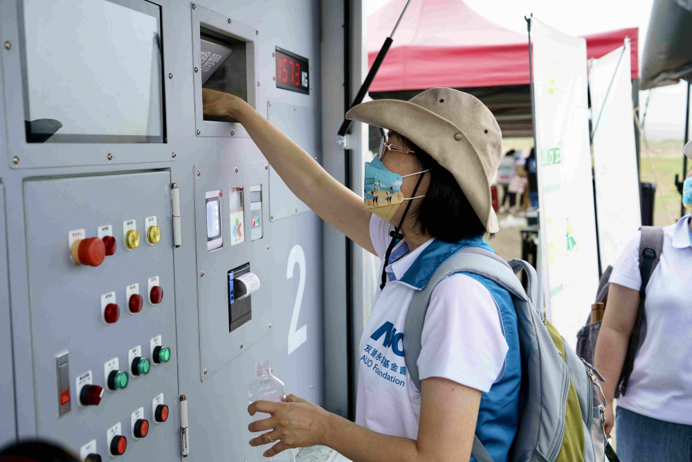 志工們將拾起的寶特瓶投入「好歸塑專車」，讓廢棄塑料空瓶可以直接粉碎、縮小體積，未來將可再製成購物袋、寶特衣、悠遊卡等生活用品